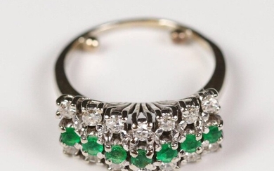 Triangular dome ring in white gold (750) set with 2 rows of 14 diamonds (for about 0.70 ct) and a line of emeralds. T: 54, Gross weight: 6.65 gr.