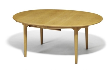 Hans J. Wegner: “JH 567”. Oak dining table, oval top with extension and one extra leaf. Solid oak frame with fold-down support leg.