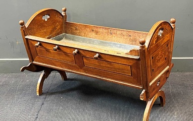 A 19th century Continental walnut and inlaid cradle