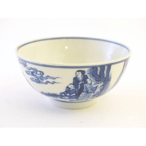 A Chinese blue and white bowl depicting scenes of figures in...