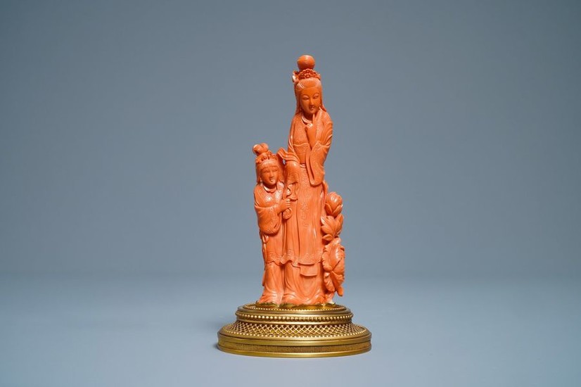 A Chinese carved red coral group of a...