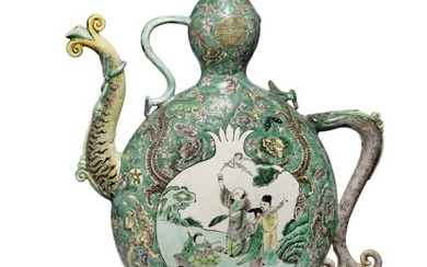 A Chinese famille verte enamel sur biscuit wine ewer decorated in colours the sides with pomegranate and peach cartouche. Qing, 18th century ? H. 30 cm.