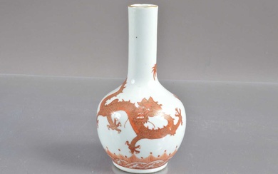 A Chinese iron red and gilt bottle vase decorated with dragons