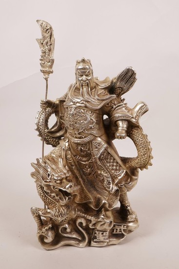 A Chinese silvered metal figure of a warrior deity standing ...