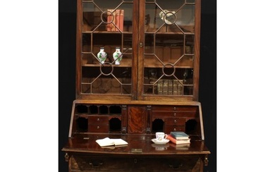 A George III mahogany bureau bookcase, outswept cornice abov...