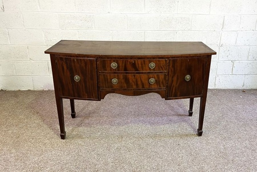 A George III style mahogany bowfront sideboard, circa 1900, with two drawers and two cupboards, on