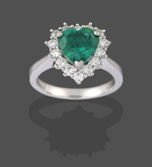 A Platinum Emerald and Diamond Cluster Ring, the heart shaped emerald within a border of round...