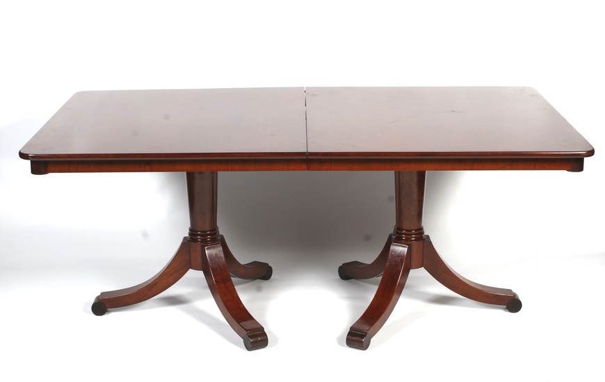 A Victorian style mahogany twin pedestal dining table. Raised on a turned column to outswept supports terminating in ball feet