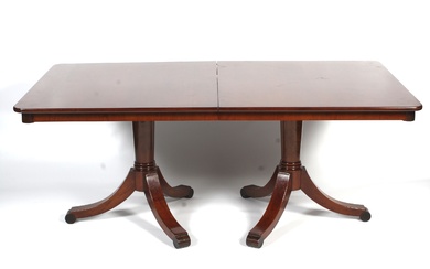 A Victorian style mahogany twin pedestal dining table. Raised on a turned column to outswept supports terminating in ball feet