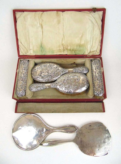 A cased late Victorian silver dressing table set with embossed...
