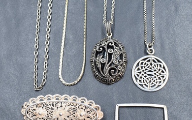 A collection of silver and white metal jewellery including a marcasite set floral motif pendant on a
