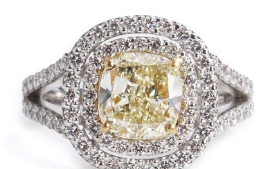 A diamond ring set with a cushion-cut fancy yellow diamond weighing app. 2.26 ct. encircled by numerous brilliant-cut diamonds weighing a total of app. 1.01 ct., mounted in 18k white gold and gold. Yellow diamond clarity: VS. Colour: Wesselton (H)...
