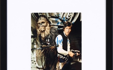 A double-signed colour photo of the actors Harrison Ford (b. 1942) and Peter Mayhew (1944–2019) in their roles as respectively Han Solo and Chewbacca.