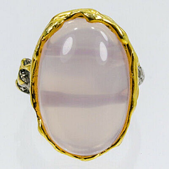 A rose quartz ring set with a carbochon rose quartz mounted in gold plated and black rhodium plated sterling silver. Size 59.