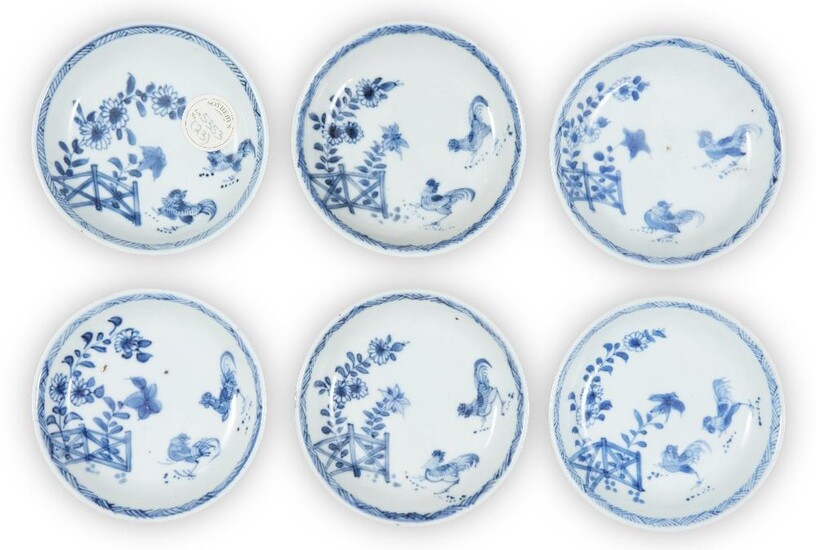 A set of six Chinese blue and white 'cockerel' saucers, 18th century, each similarly painted to the interior with cockerels beneath branches of chrysanthemum and morning glories behind a fence, all below a diagonally lined band to rim, 10.3cm...