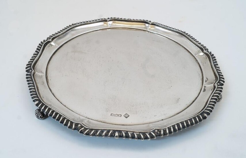 A silver salver, Sheffield, 1924, William Lister & Sons, with scalloped and gadrooned rim on three scroll feet, 26.1cm dia., weight approx. 18.2oz