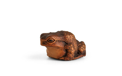 A wood netsuke of a toad The surface of the...