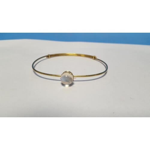 AN UNMARKED YELLOW METAL BANGLE SET WITH A MOONSTONE. Approx...