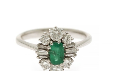 An emerald and diamond ring set with an emerald-cut emerald encircled by six brilliant- and six emerald-cut diamonds, mounted in 18k white gold. Size 55.