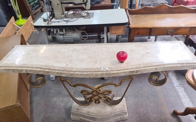 An ornate marble-top console table with a gilded wrought iro...