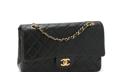 Chanel: A “Classic Double Flap bag” made of quilted black calf leather, gold toned hardware, double chain strap and an open exterior pocket.