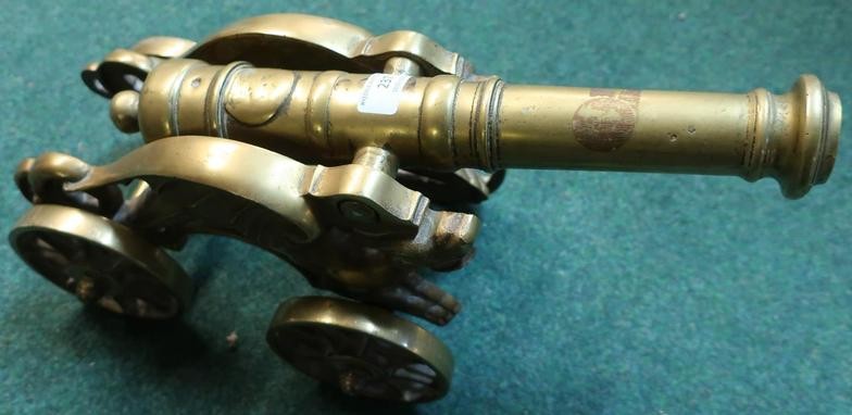 Heavy cast brass model of a cannon on four...