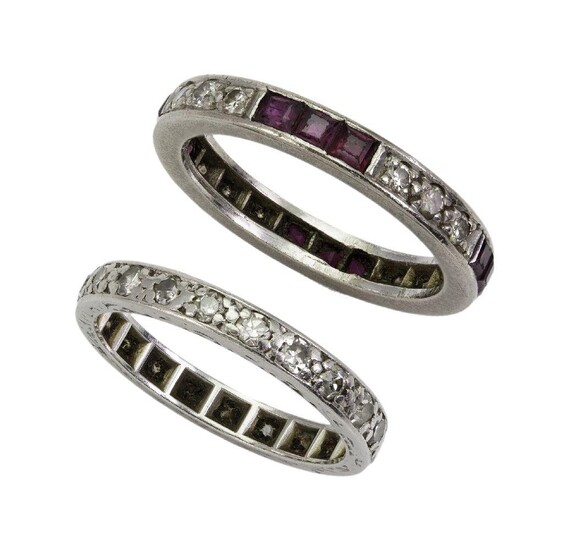 Two diamond eternity rings, one composed of a single row of alternate set three stone single-cut diamonds and ruby line, ring size L; the other a single-cut diamond single row, ring size I, both c.1925 (2)
