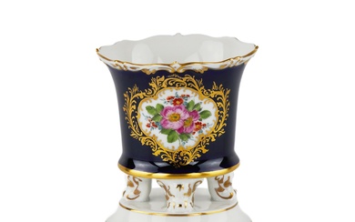 Un petit vase sur quatre pieds frises reposant sur un piedouche rond. Manufacture de Meissen....