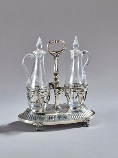 Vinegar oil cruet in openwork silver resting on an oblong quadripod base with a claw-like end decorated with a frieze of eggs and flowers at the ends. Openwork receptacles underlined with garlands, leafy catch.
