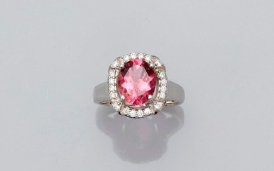 White gold ring, 750 MM, centered on an oval pink tourmaline weighing 2.51 carats set by four diamond claws and hemmed with brilliants, size: 53, weight: 7.35gr. rough.