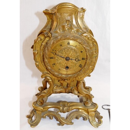 A 19th century gilt brass Rococo style mantle timepiece, the...