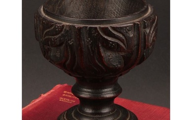 A 19th century oak goblet or chalice, the bowl carved with a...