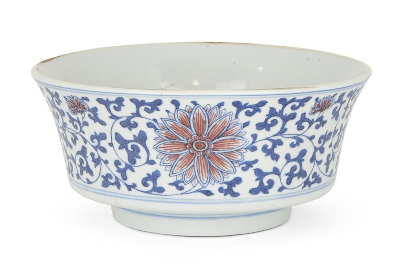 A Chinese porcelain blue and copper-red bowl, 19th century, decorated to the exterior with flowering lotus scrolls, apocryphal underglaze blue Wanli mark to base, 17cm diameter