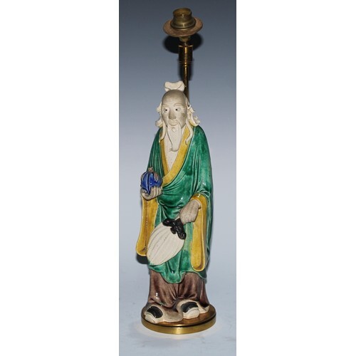 A Chinese sancai stoneware figure, of an elder holding a pea...