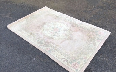 A Chinese wool rug woven in pastel floral shades with...