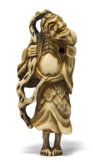 A Japanese stag antler netsuke, 19th century, carved as a sennin with long beard and staff, gourd slung across his shoulder, 8cm high