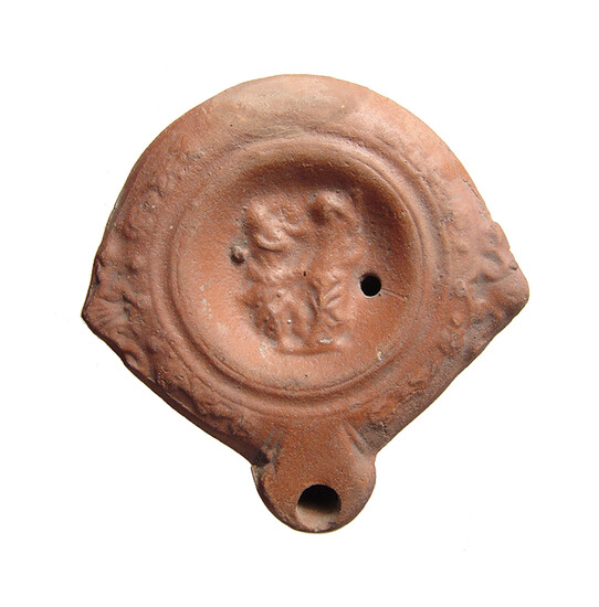 A Roman red-ware oil lamp with satyr and other figure