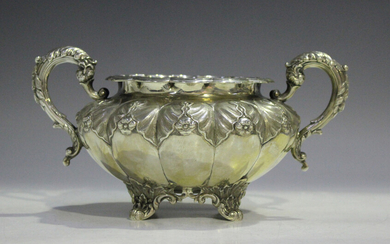 A Victorian silver circular two-handled sugar bowl, the lobed body cast with a band of stylized leav