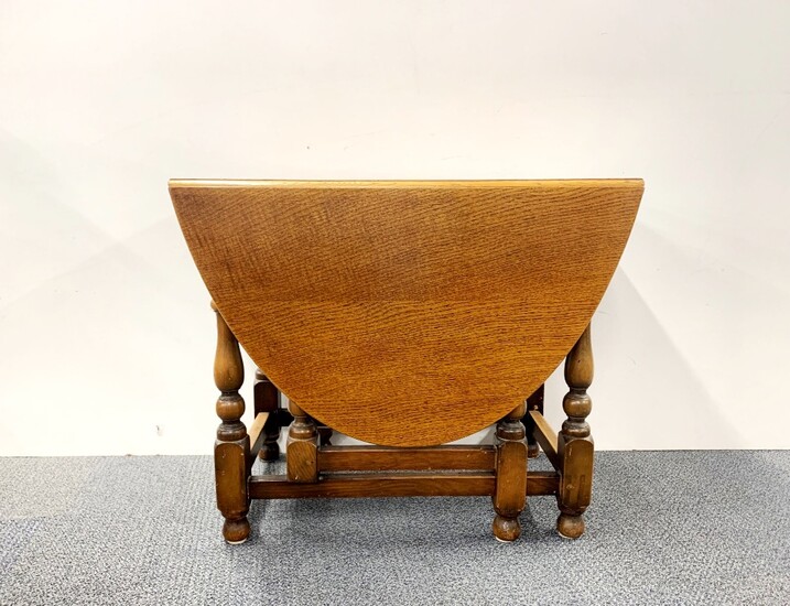 A golden oak drop leaf dining table, L. 49cm. Extending to 148cm.
