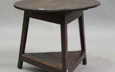 A late 18th century provincial oak circular cricket table, raised on block legs, united by an undert