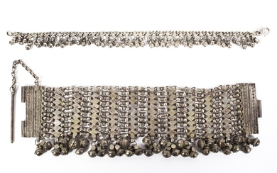 A late 19th century Omani white metal chain link bracelet with hanging bell decoration, 23cm long