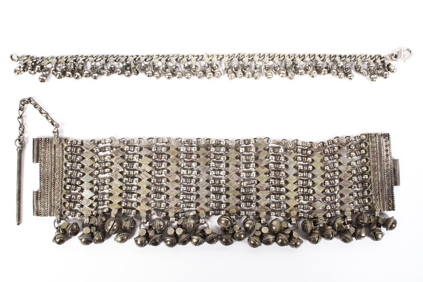 A late 19th century Omani white metal chain link bracelet with hanging bell decoration, 23cm long