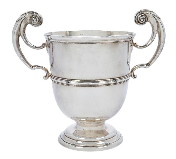 A late Victorian twin handled cup, London, 1899, Charles Stuart Harris, with bifurcated scroll handles and reeded band to body, raised on a stepped circular foot, 24cm high (inc. handles) approx. weight 39oz