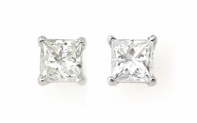 A pair of diamond ear studs each set with a princesss-cut diamond...
