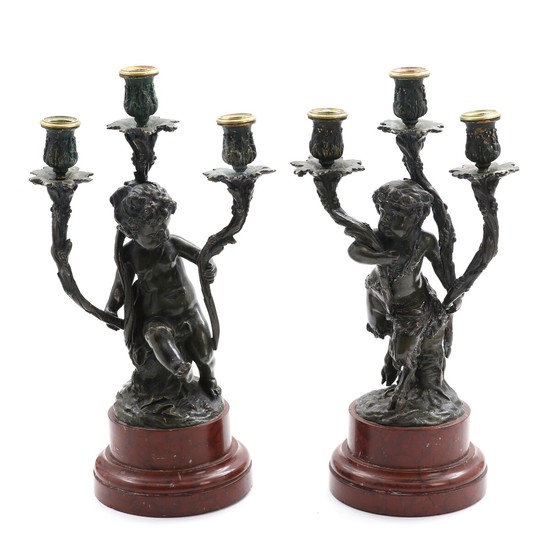 A pair of late 19th century patinated bronze candelabras in the shape of a putto and a faun, reddish marble bases. H. 43 cm. (2)