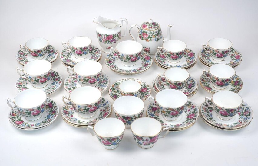 A quantity of Crown Staffordshire tea set pieces, early 20th century, decorated with a floral bordering pattern, comprising: a teapot and cover 14cm high overall, a milk jug, seven large teacups 9.6cm diameter, seven medium teacups 8.8cm diameter...