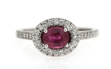 NOT SOLD. A ruby and diamond ring set with an oval-cut ruby encircled by numerous...