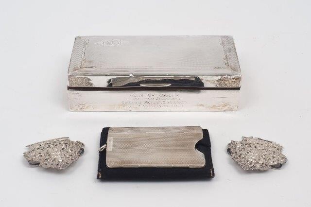 A silver cigarette box, Birmingham, 1934, Sanders & Mackenzie, with engine turned lid and presentation engraving to front, 8.8 x 17cm, together with an Asprey & Co. collapsible silver card holder, Birmingham, 1961, of engine turned design, and a...