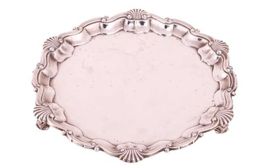 A silver salver by Goldsmiths and Silversmiths Company, London 1916, with piecrust and shell rim, on