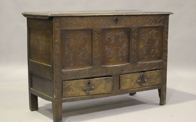 An 18th century oak mule chest, the hinged lid above a carved panel front and two drawers, on stile